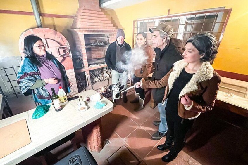 Un gruppo di persone in cucina attorno a un forno a mattoni. 3