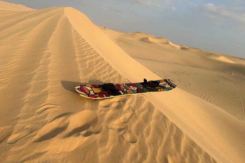 A snowboard on a sand dune. 3