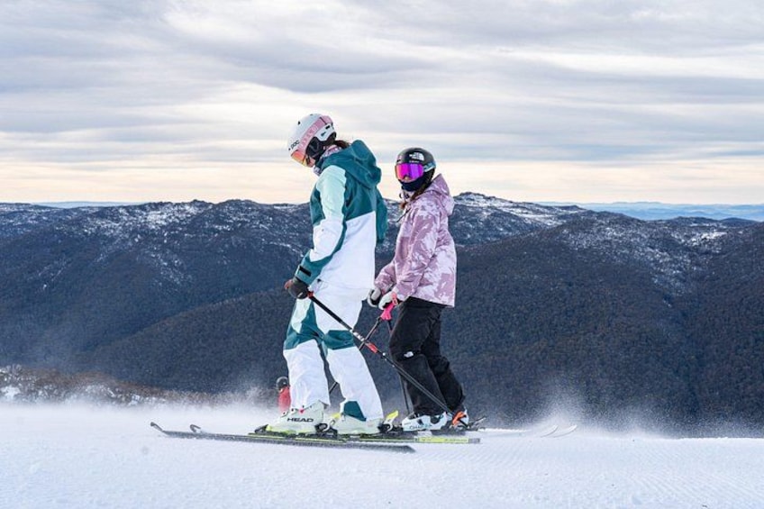 Two people skiing on a snowy mountain slope. 1