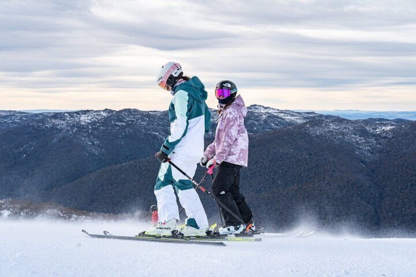 Two people skiing on a snowy mountain slope. 1