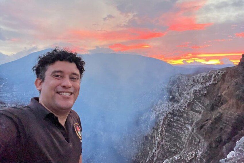 A person standing on a mountain with a sunset in the background. 1