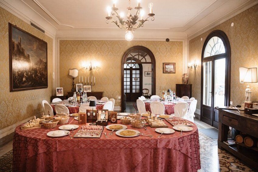 Ein formeller Speisesaal mit einem runden Tisch, gedeckt für eine Mahlzeit, umgeben von Stühlen. 5