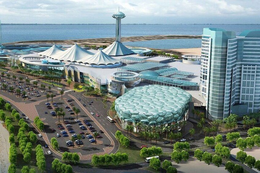 A coastal resort with a distinctive tower, a large dome-shaped building, and a parking area. 2