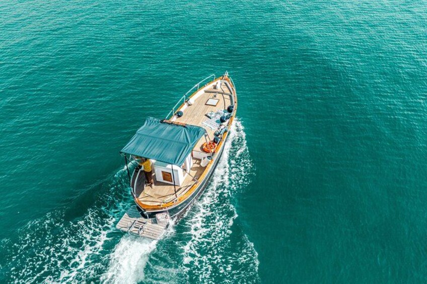 Un bateau doté d’un auvent, naviguant sur une eau turquoise. 1