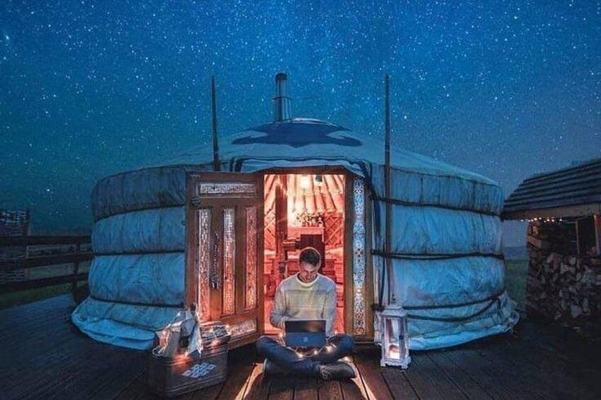 A person sitting inside a yurt with a starry night sky. 4