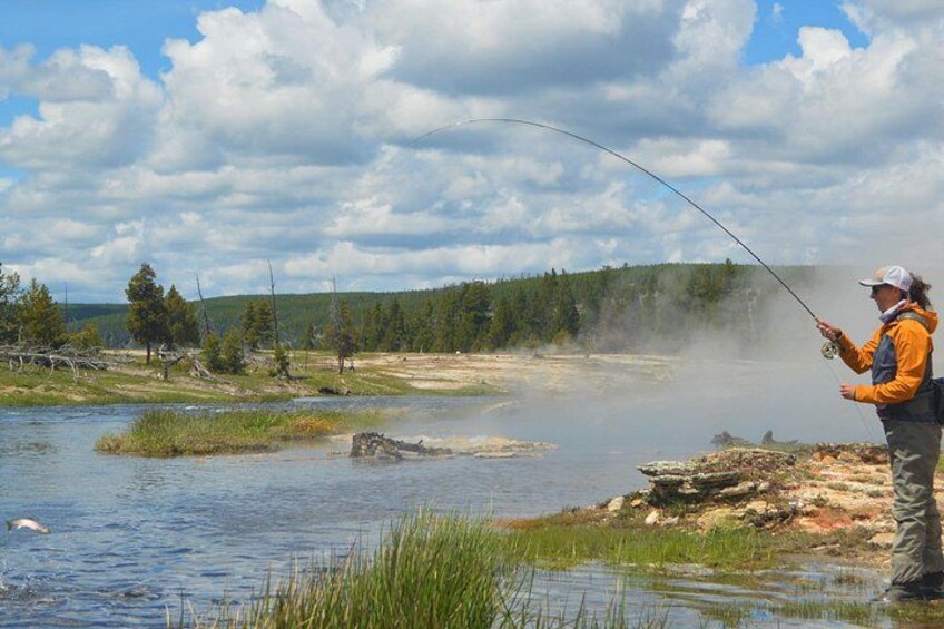 Une personne est en train de pêcher au bord d’une rivière, et de la vapeur s’élève de l’eau. Elle est entourée d’arbres et le ciel est dégagé. 2