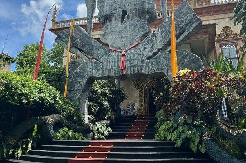 A temple entrance with a large stone structure, steps, and decorative plants. 5