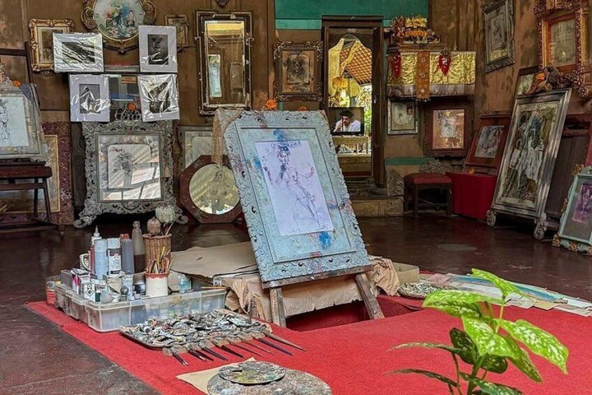 An art studio with various paintings, frames, and art supplies. 3