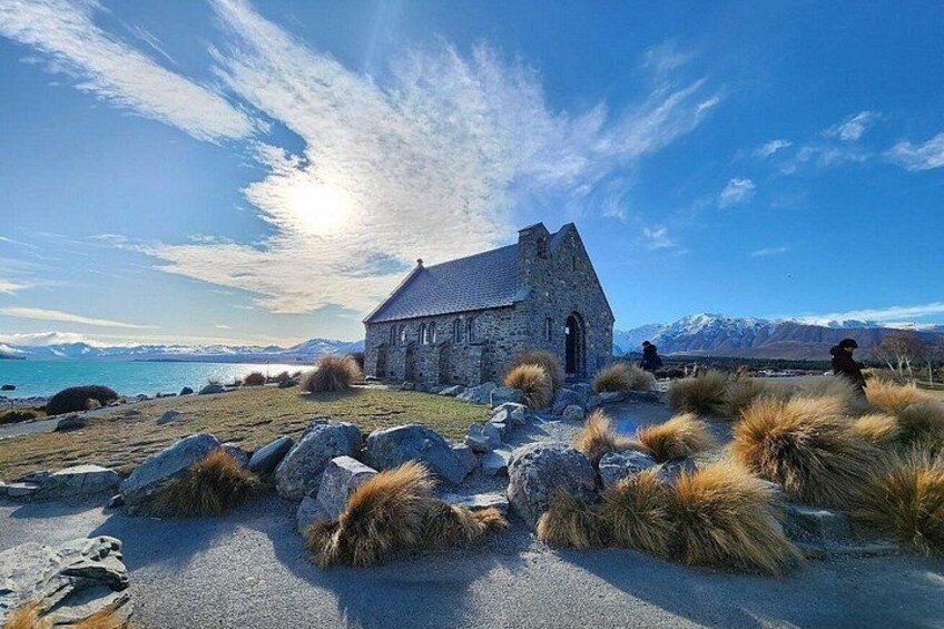 A stone church with a clear sky and mountains in the background. 5
