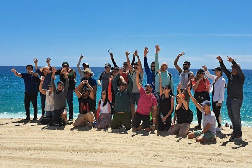 En gruppe mennesker på en strand med havet i baggrunden. 5