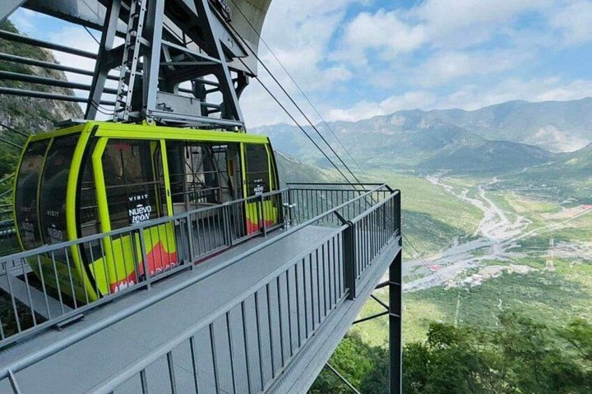 A cable car with 'Visit' and 'MIEVO' text, a bridge, and a mountainous landscape. 3