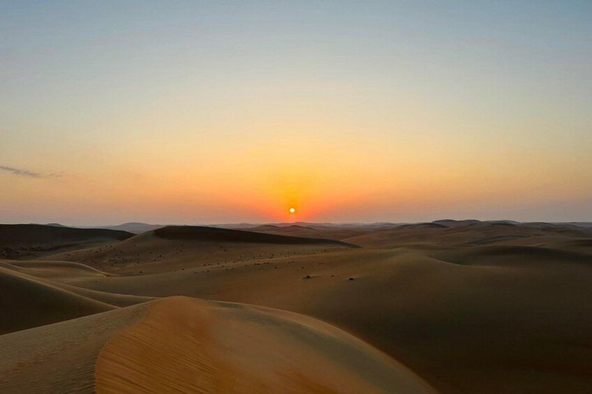 A desert landscape with sand dunes and a sunset. 4