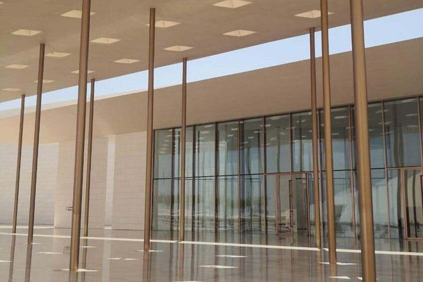 A modern building with large glass windows and a reflective floor. 3