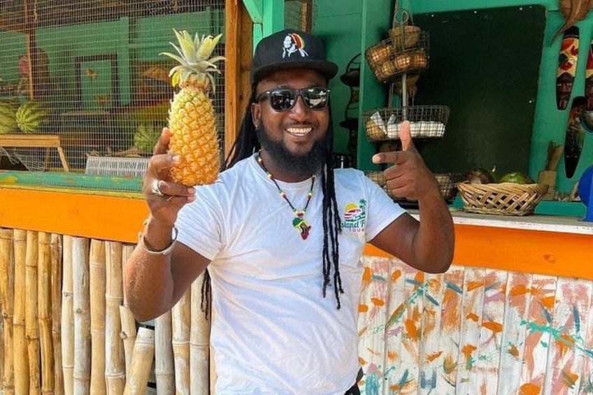 A person holding a pineapple, wearing a white t-shirt, and a black cap with a logo. 4