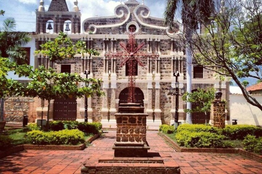 A colonial-style building with a central fountain, surrounded by well-maintained hedges and a brick pathway. 4