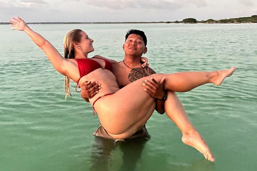A man carrying a woman on his shoulders in a body of water. 3
