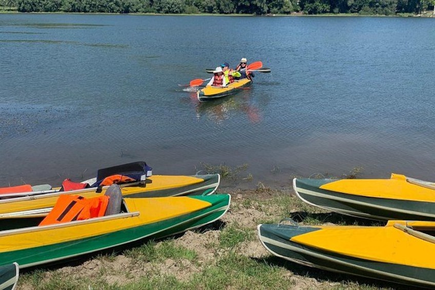 A calm lake with several kayaks and a canoe on the shore. 2