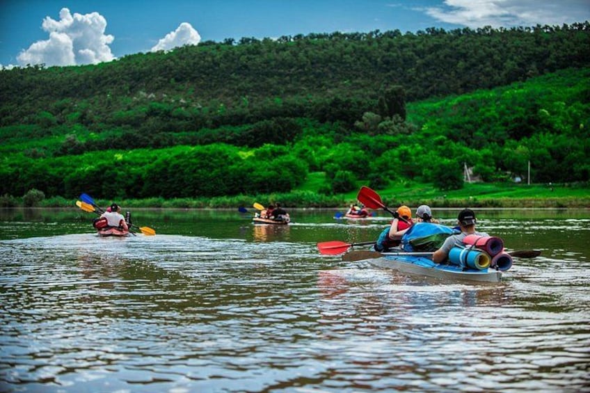 People kayaking on a river surrounded by lush greenery. 1