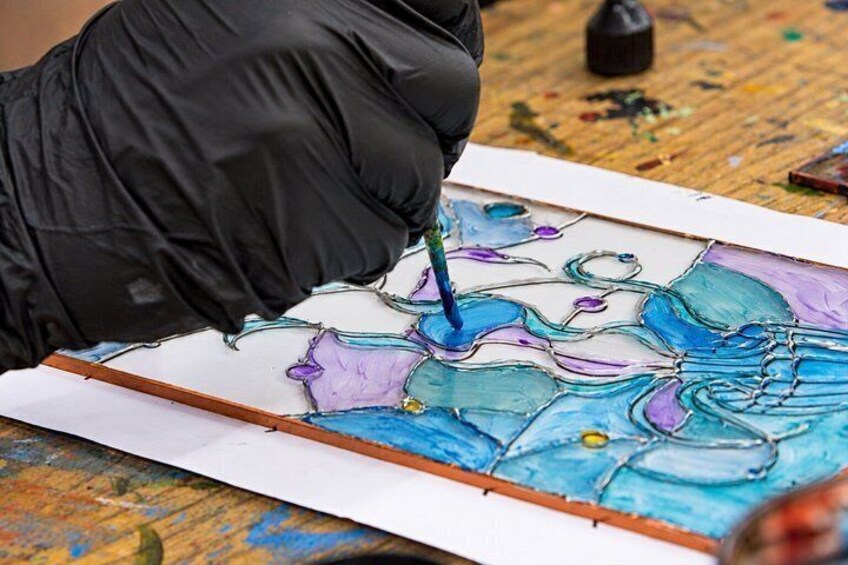 A person painting a colorful abstract design on a canvas. 3