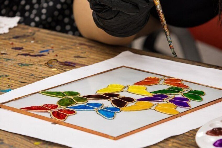 A person painting a colorful abstract design on paper. 2