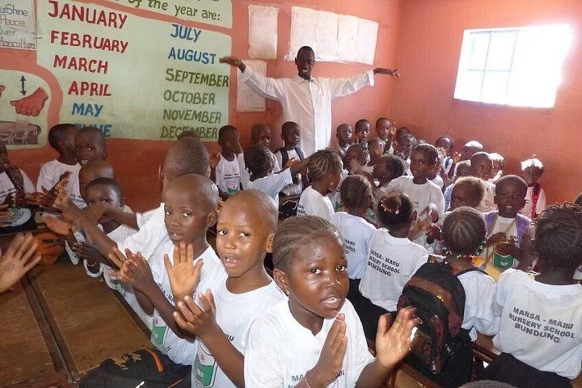 A classroom with children and a teacher. 5