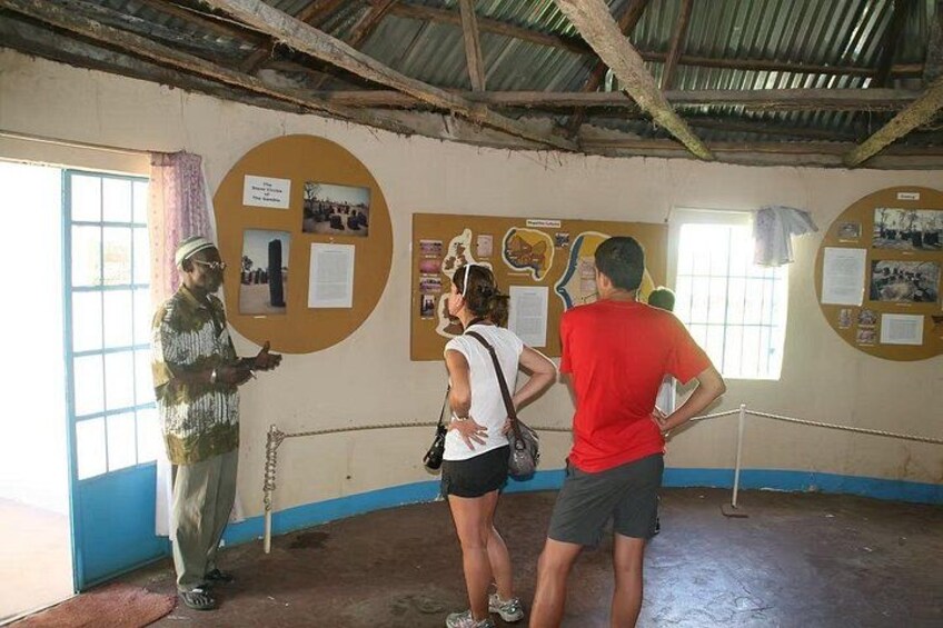 A group of people in a museum with informational displays on the walls. 2