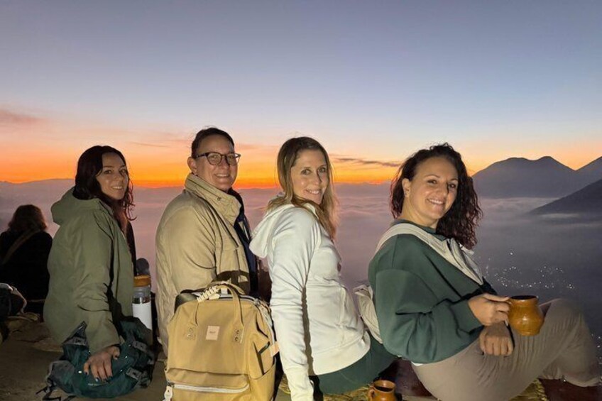 A group of people standing on a mountain ridge at sunset. 2