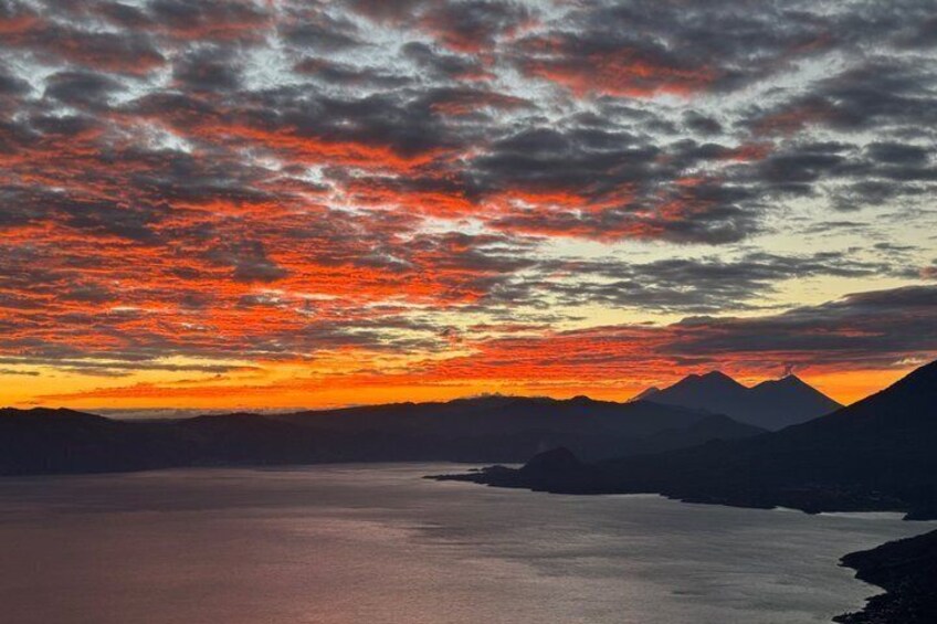 A sunset over a lake with mountains in the background. 4