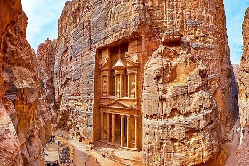 Eine in Fels gehauene Architektur mit Säulen und einer zentralen Nische, umgeben von schroffen Klippen. 3