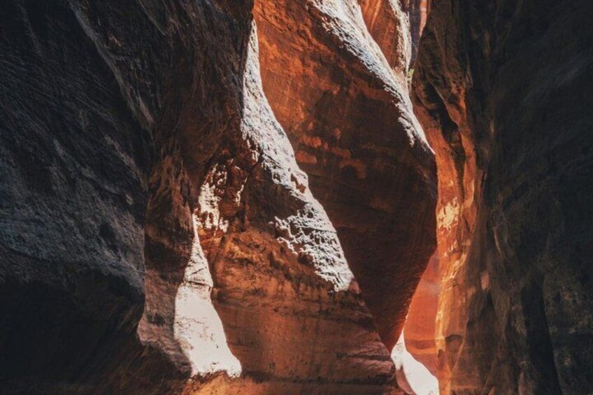 A canyon with red rock formations and a narrow passageway. 5