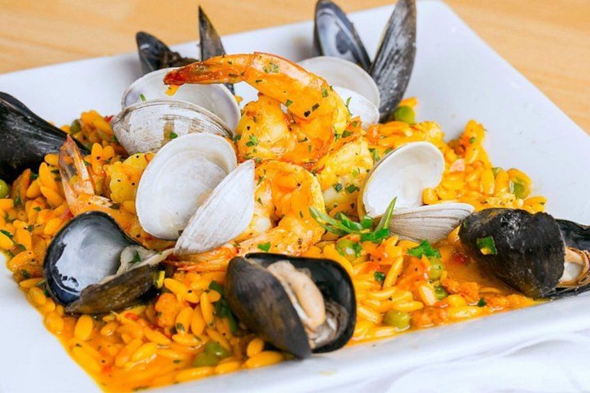 A seafood dish with mussels, clams, and shrimp on a plate. 5