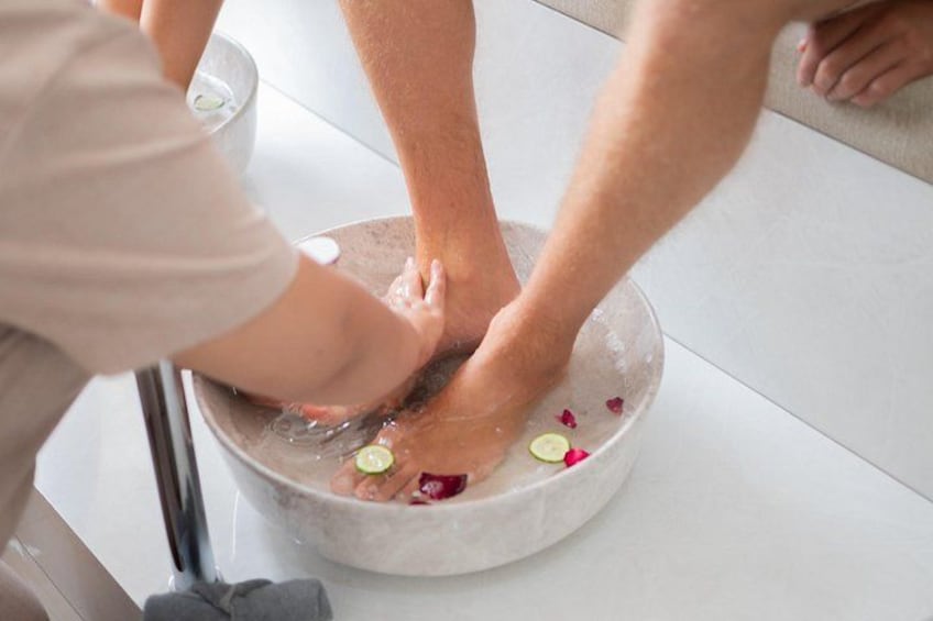 A foot soak with flowers and a glass of water. 1