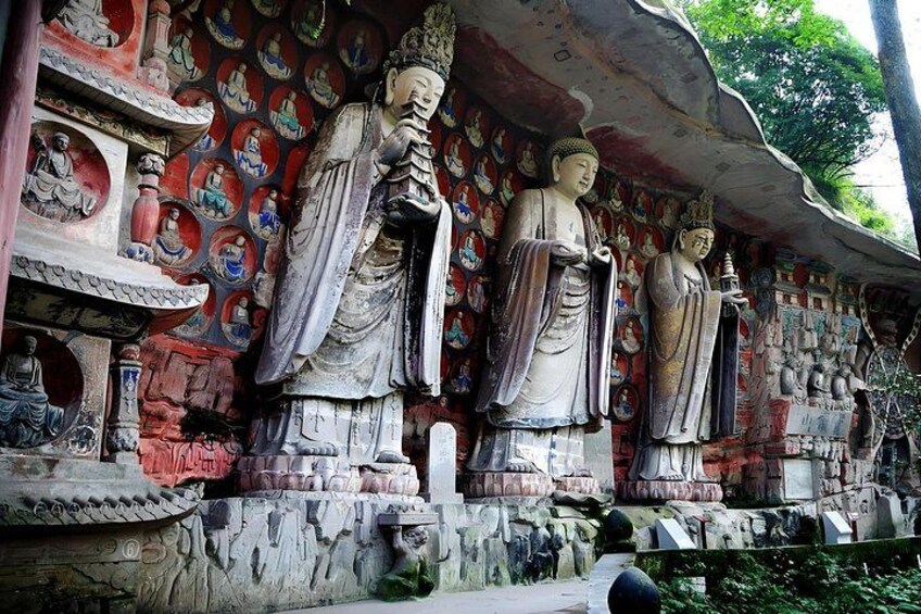 Large Buddha statues in a temple with intricate wall paintings. 1