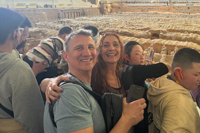 A group of people standing in an ancient amphitheater with stone seating. 1