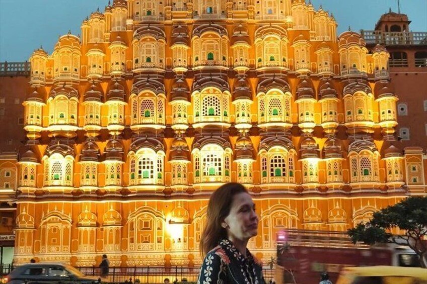 A brightly lit, ornate building with multiple balconies and windows, likely a historical or cultural landmark. 3