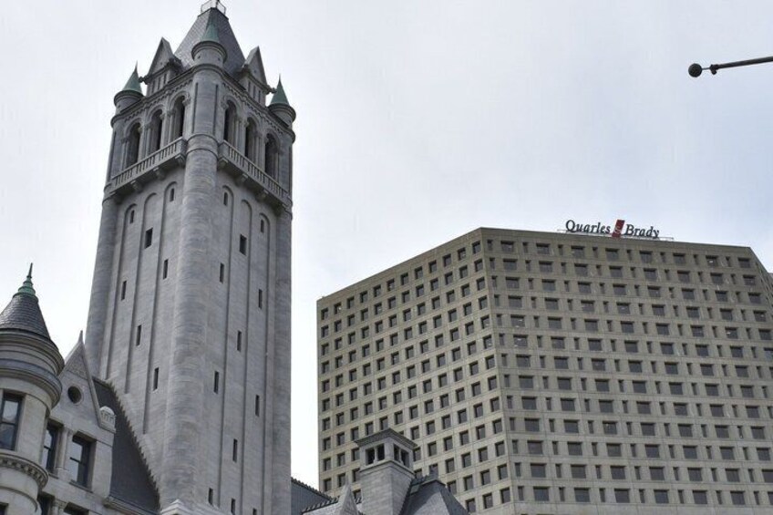 A historic tower and a modern building with 'Quarles Brady' signage. 5