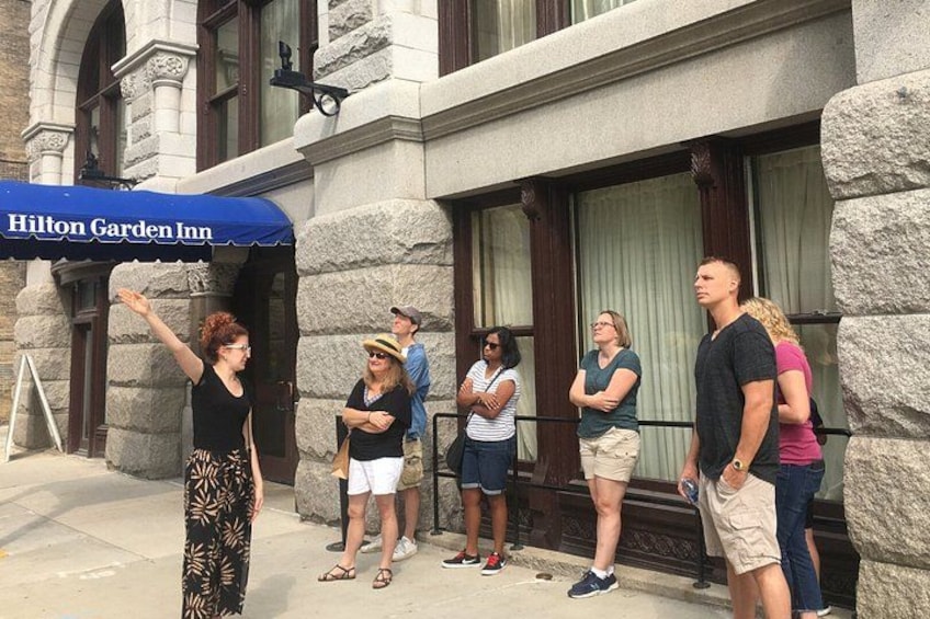 A group of people standing outside a building with a blue awning that reads 'Hilton Garden Inn.' 3