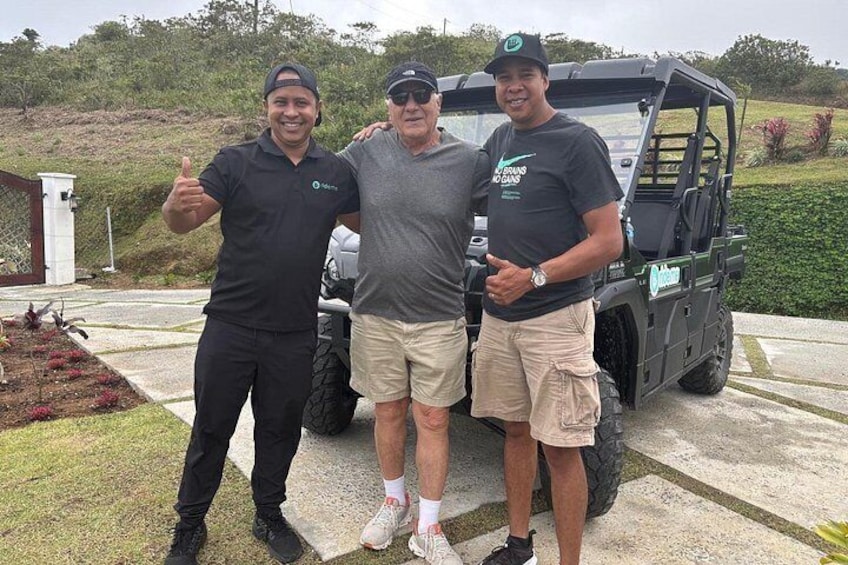 Three people standing in front of a golf cart. 3