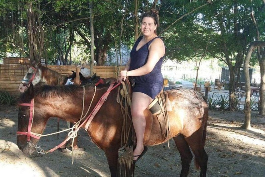 Une personne à cheval, évoluant dans un environnement extérieur, avec des arbres et une clôture en bois en arrière-plan. 3