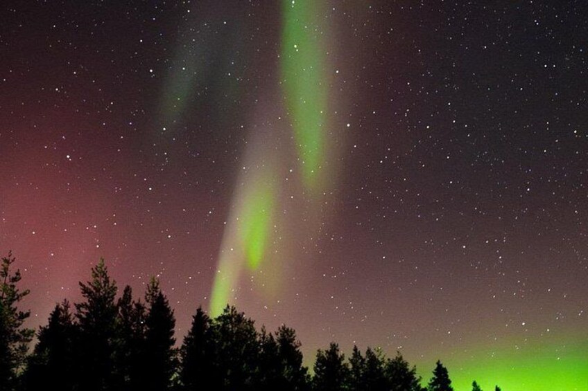 A night sky with visible stars and green aurora borealis. 3