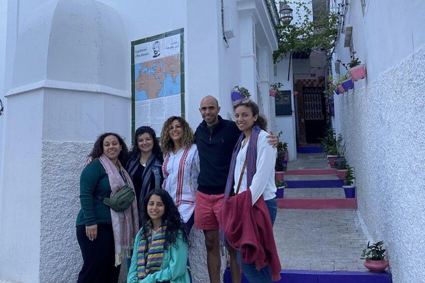Un grupo de personas parada en un callejón estrecho con paredes blancas y un mapa en la pared. 3