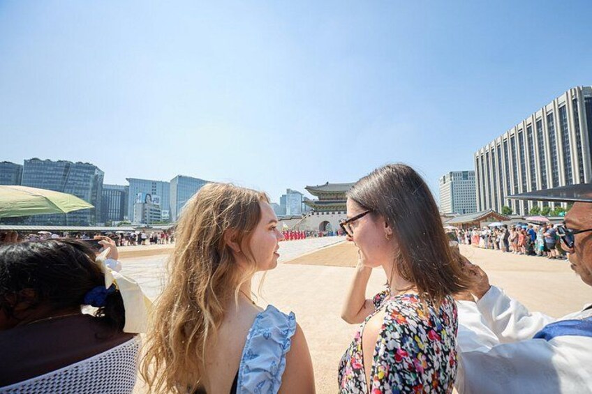 A group of people at a public square with modern buildings in the background. 5