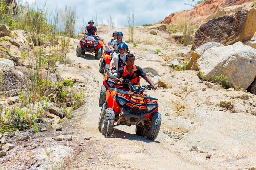 A group of people riding ATVs on a rocky trail. 1