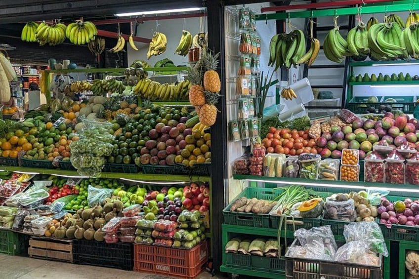 A fruit and vegetable market with various fruits like bananas, apples, and oranges displayed in crates. 1