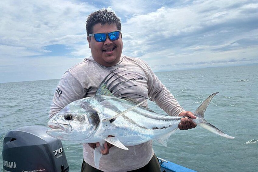 A person holding a large fish on a boat with a Yamaha outboard motor. 5