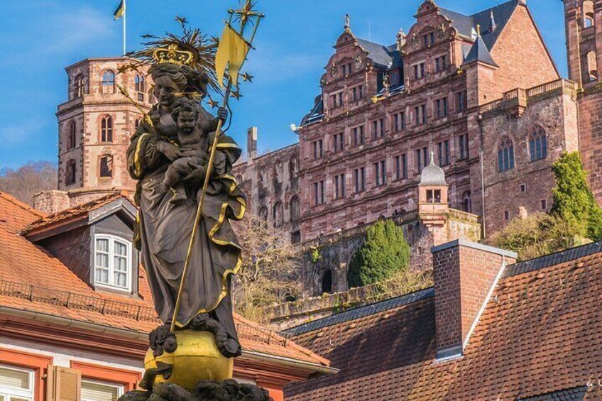 Una estatua que muestra una figura sosteniendo a un niño, un castillo y una iglesia. 3