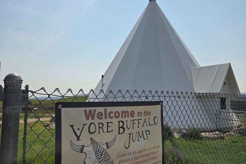 A welcome sign for the Vore Buffalo Jump, a historical site with a large white conical structure. 2
