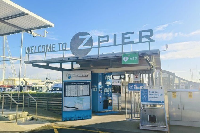 A pier entrance with a sign reading 'WELCOME TO Z PIER,' an AED symbol, and a 'NO FISHING' sign. 2