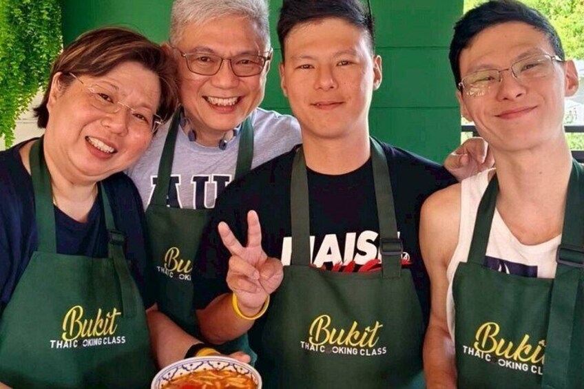 Four people wearing aprons with the text 'Bukit Thaic Cooking Class.' 3