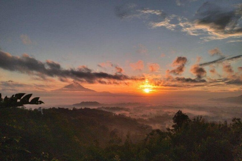A sunset over a mountainous landscape with clouds. 1